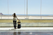 Girl at the airport window looking to the ocean
