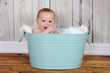 adorable baby sitting in hapily green washtub