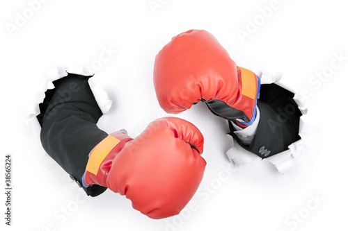 Photo: Businessman's hand in fight position wearing boxing gloves Businessman's hand in fight position wearing boxing gloves