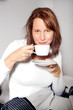 Frau genießt einen Kaffee im Bett