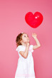 Girl playing with heart shaped balloon