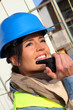 Site manager using walkie-talkie on building site Site manager using walkie-talkie on building site