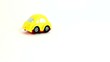 Little yellow toy car rides and turns over