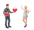 Boyfriend standing with a pillow and a girlfriend extending her