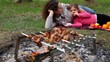 Mother and daugther lay on plaid, fruit are near them