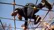 Kids climb on rope lattice at playground, view from below