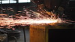Men at work grinding steel