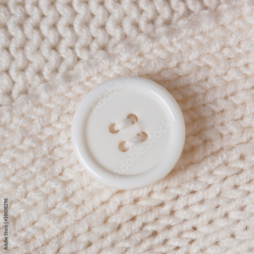 Photo: High Resolution knitted texture with a white button background High Resolution knitted texture with a white button background