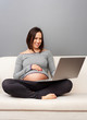 pregnant woman looking at laptop