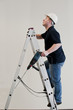 man enters the ladder with drill