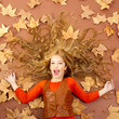 autumn fall little blond girl on dried tree leaves