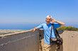 Man with a photo bags on a background of sky and sea