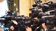 Some videocameras with operators recording presentation
