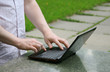 Hands and netbook on street