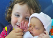 Litlle girl dicovering her newborn sister Litlle girl dicovering her newborn sister