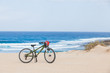 Bicycle with helmet, stand on the beach.