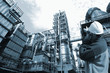 oil worker and chemical refinery, blue toning.