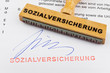 Holzstempel auf Dokument: Sozialversicherung
