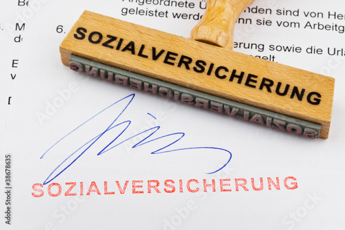 Foto: Holzstempel auf Dokument: Sozialversicherung Holzstempel auf Dokument: Sozialversicherung