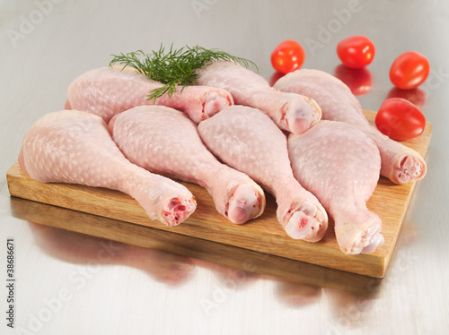 Photo: Fresh raw chicken drumsticks arrangement on cutting board Fresh raw chicken drumsticks arrangement on cutting board