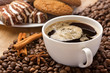Coffee cup, cinnamon, anise on coffee beans and sweets