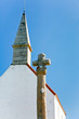 old stone cross and roof of country chapel