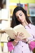 female student reading a book in library