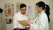 Video: Latina Doctor in clinic shows patient lab results Latina Doctor in clinic shows patient lab results