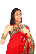 Young Indian girl in traditional clothing with thumbs up.