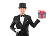 Young magician holding a magic wand and a gift Young magician holding a magic wand and a gift