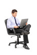 Young smiling businessman sitting in office chair and working on Young smiling businessman sitting in office chair and working on