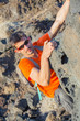 Young man in glasses with backpack climbing
