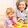 Photo: Little girl eat apricot fruit with grandmother Little girl eat apricot fruit with grandmother