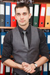 Handsome male business executive standing behind a bookstand