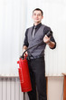 Photo: White collar worker with fire-extinguisher in office room White collar worker with fire-extinguisher in office room