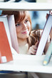 young student girl at book shelf in library