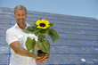 Mann mit Sonnenenergie-Sonnenblume.