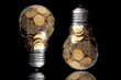 Traditional glass bulb with many golden coins on black Traditional glass bulb with many golden coins on black
