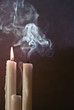 Burning candle and two extinguished candles