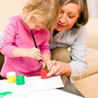 Photo: Little girl with grandmother play paint handprints Little girl with grandmother play paint handprints