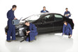 Mechanic looking at camera in studio with car
