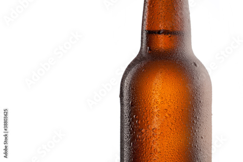Photo: Beer bottle with water drops and frost isolated on white Beer bottle with water drops and frost isolated on white