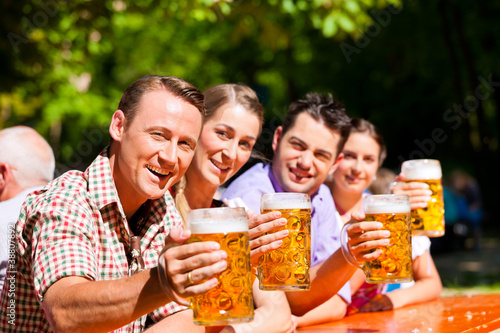 Photo: Zwei glückliche Paare sitzen im Biergarten Zwei glückliche Paare sitzen im Biergarten