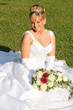 Foto: Schöne, blonde Braut im Brautkleid auf grüner Wiese Schöne, blonde Braut im Brautkleid auf grüner Wiese