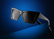 Closeup trendy sunglasses on the dark blue abstract background Closeup trendy sunglasses on the dark blue abstract background