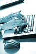 Blue toned image of a businesswoman typing on the laptop Blue toned image of a businesswoman typing on the laptop