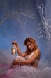 Elf in magical winter forest with lantern.