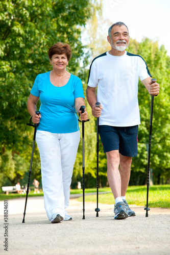 Photo: senior couple making nordic walking senior couple making nordic walking