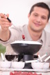 Photo: 30 years old man eating meat fondue 30 years old man eating meat fondue