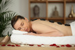 Laid woman having hot stones massage